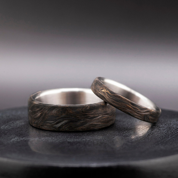 Elegante anillo de titanio con láminas de oro y fibra de carbono