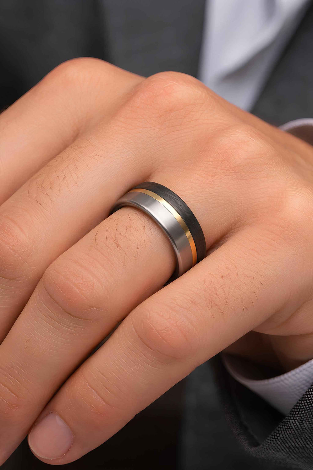 Man wearing titanium carbon fiber ring with brass inlay - handcrafted mens wedding band on hand