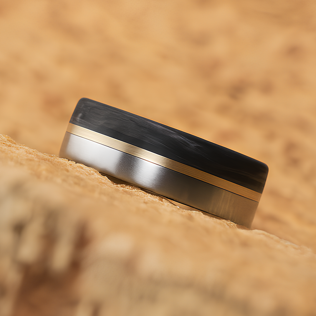 Flat-profile titanium ring featuring a carbon fiber half and a slim brass inlay stripe