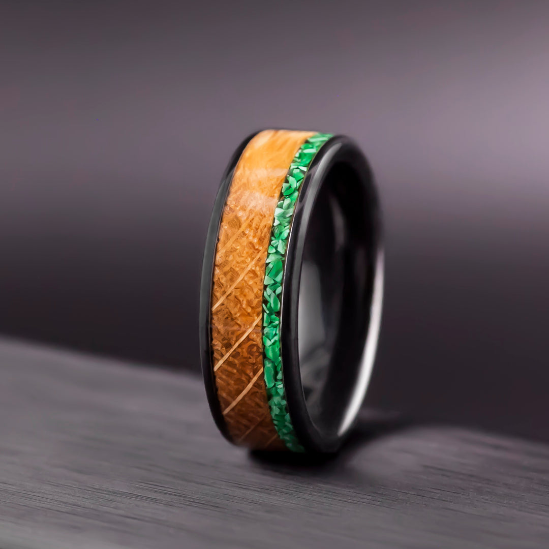 Black ceramic wedding band featuring whiskey barrel oak and a malachite inlay stripe