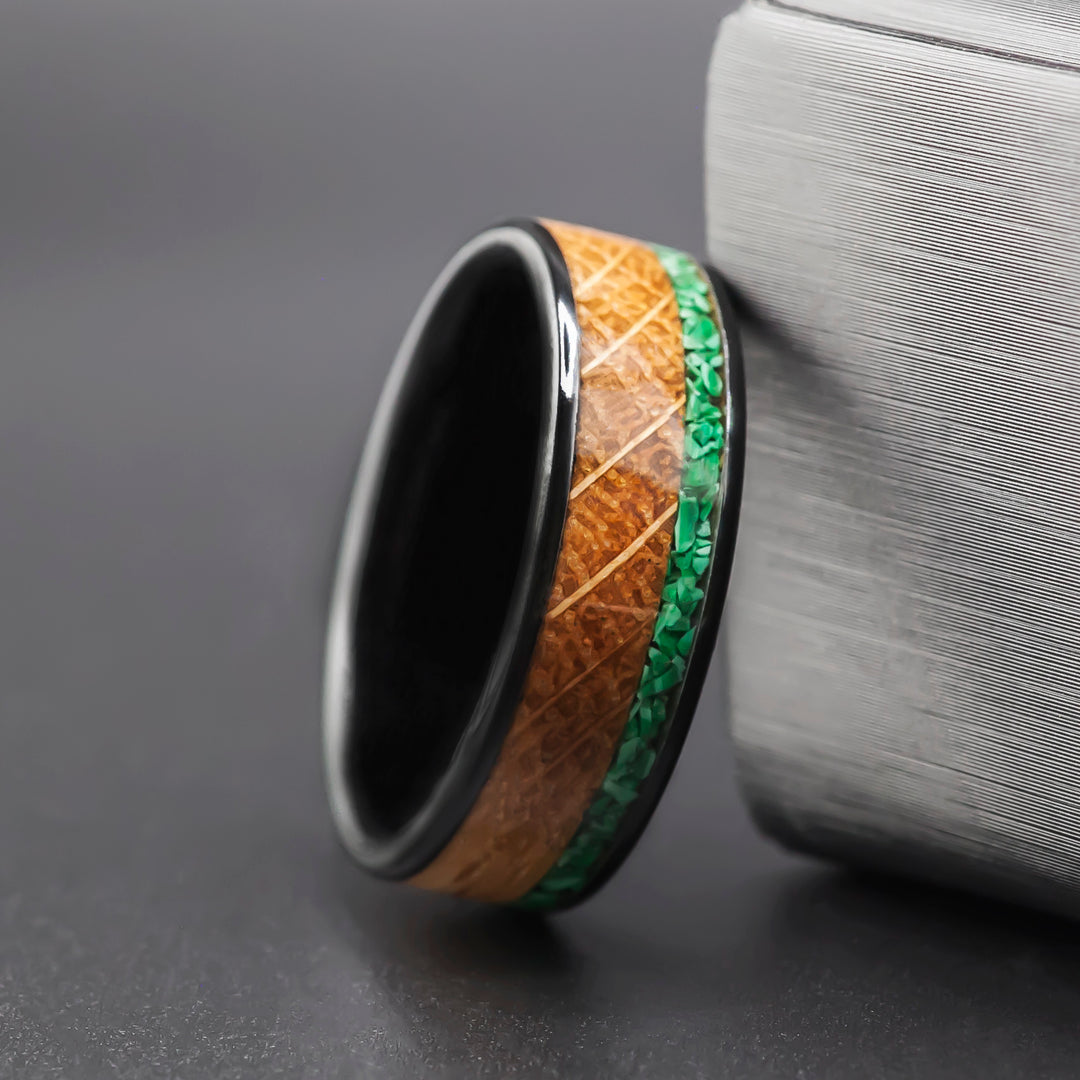 The Cask malachite inlay ring with whiskey barrel oak on a black ceramic band