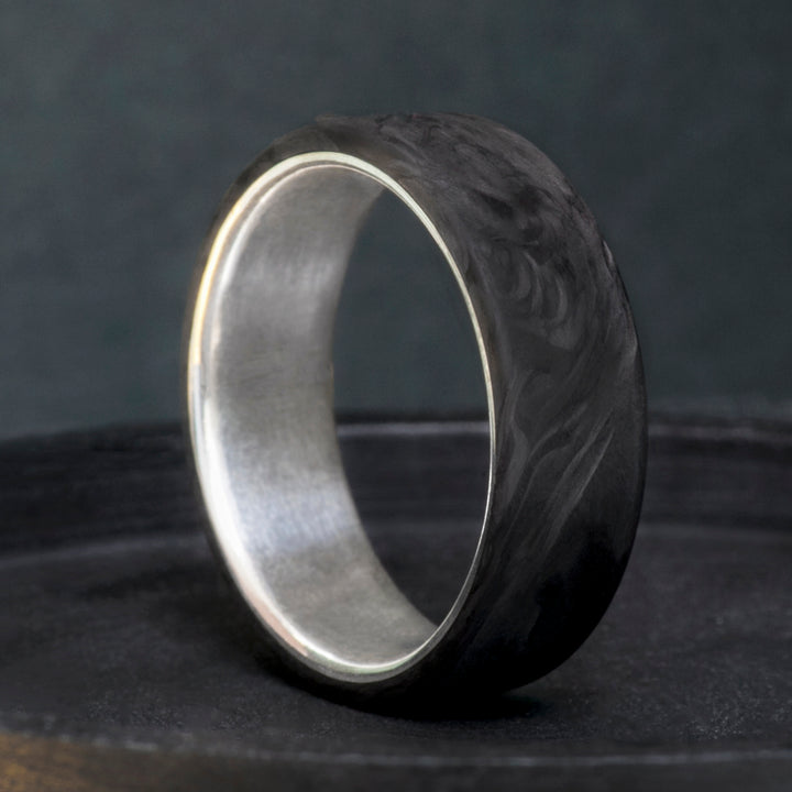 Handcrafted forged carbon fiber wedding band with brushed sterling silver lining