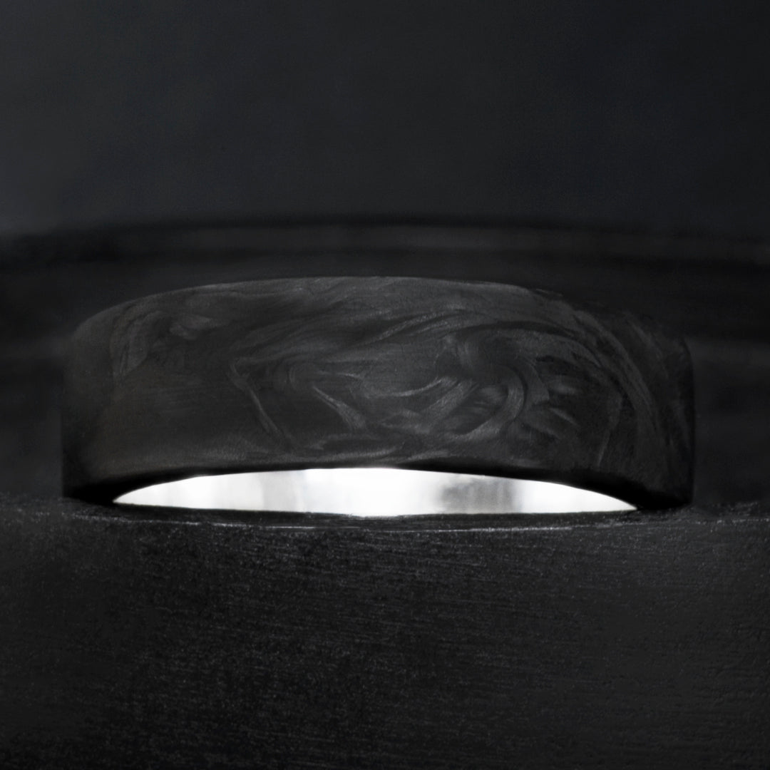 Domed forged carbon fiber ring with sterling silver core and organic black grain pattern