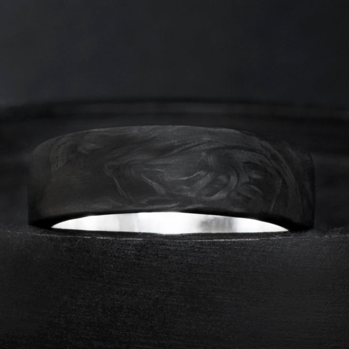 Domed forged carbon fiber ring with sterling silver core and organic black grain pattern