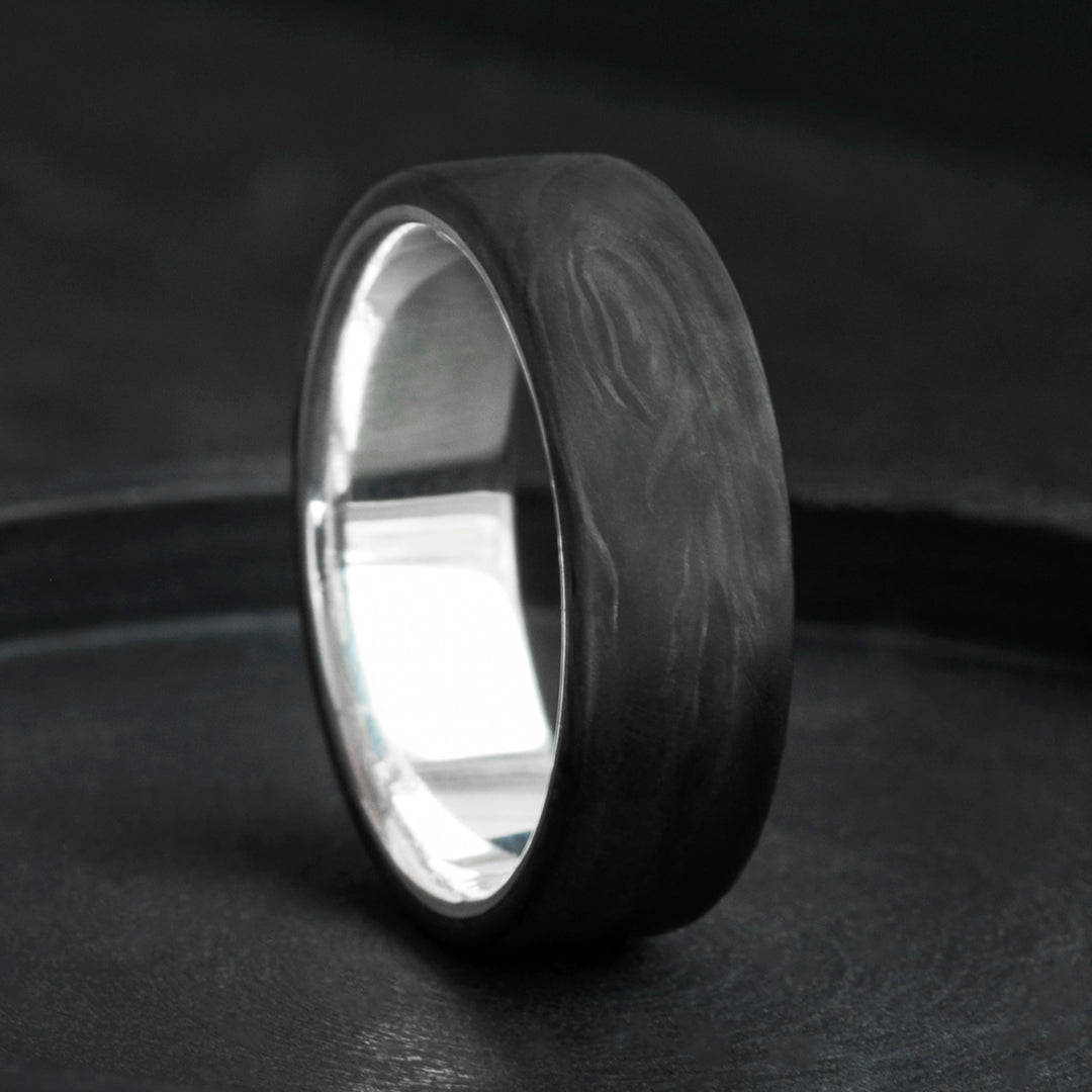 Forged carbon fiber mens wedding band with sterling silver core, domed black marbled finish