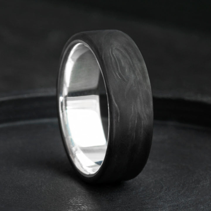 Forged carbon fiber mens wedding band with sterling silver core, domed black marbled finish