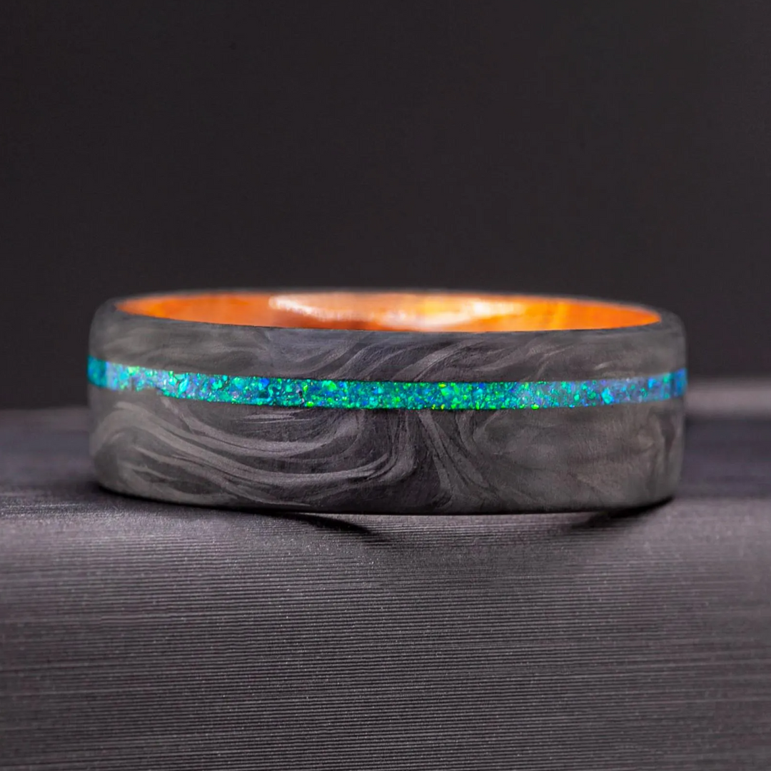 Mens carbon fiber ring showing an Amboyna wood sleeve interior with warm amber grain