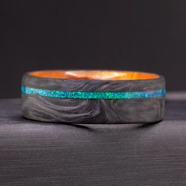 Mens carbon fiber ring showing an Amboyna wood sleeve interior with warm amber grain