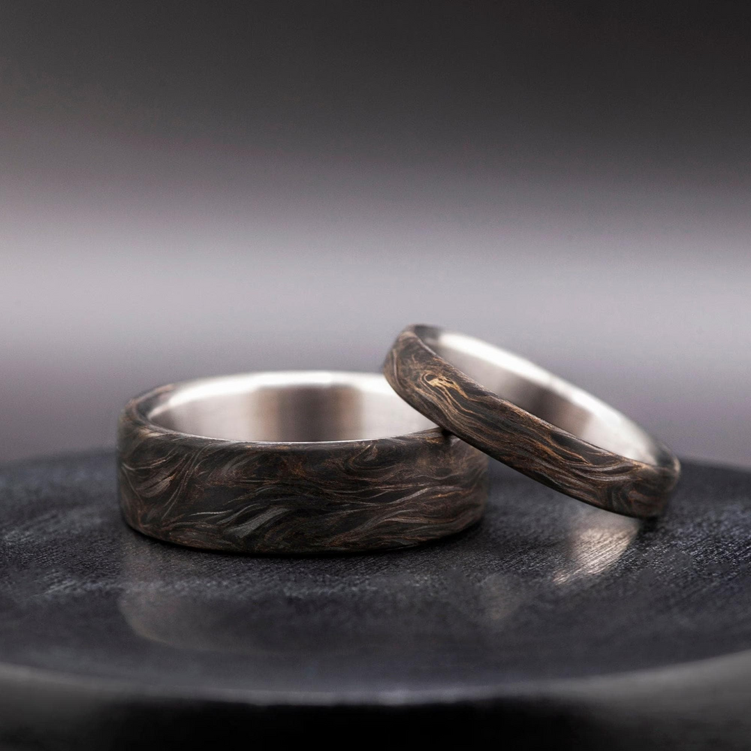 Mens titanium wedding band wrapped in carbon fiber with shimmering gold leaf detail