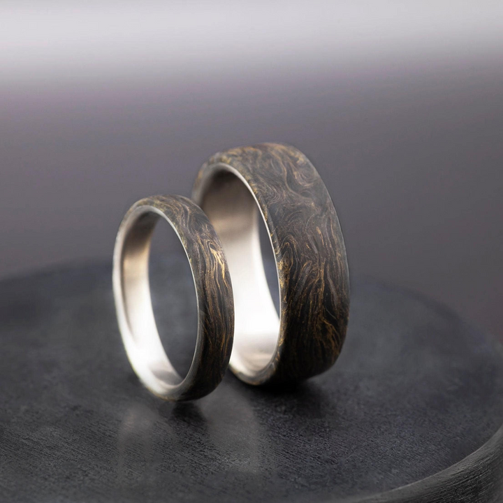 Domed titanium ring with forged carbon fiber and gold leaf over a polished interior