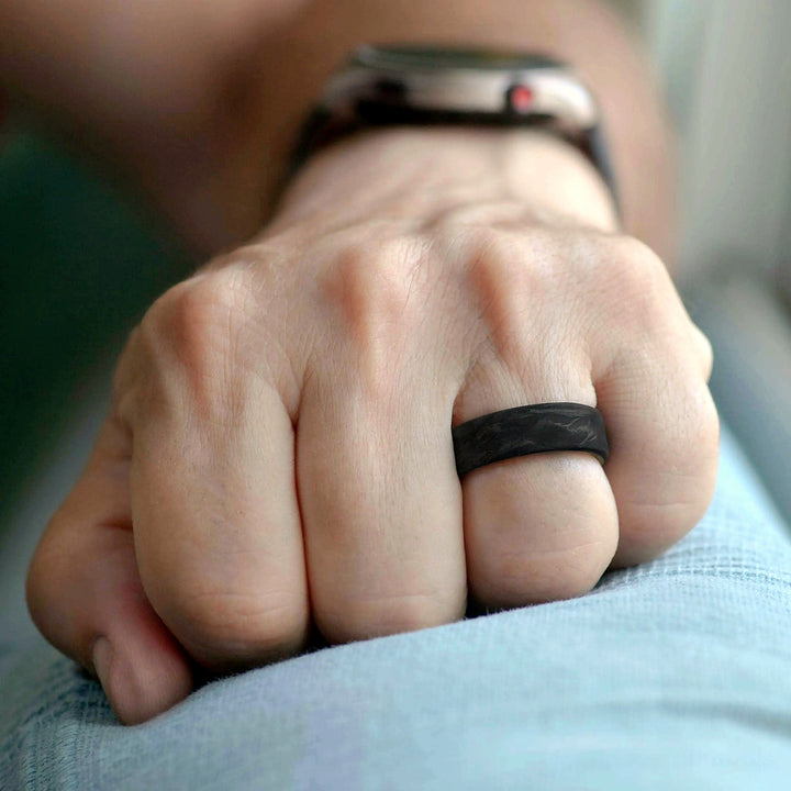 Man wearing carbon fiber ring with California Redwood interior - handcrafted mens wedding band on hand