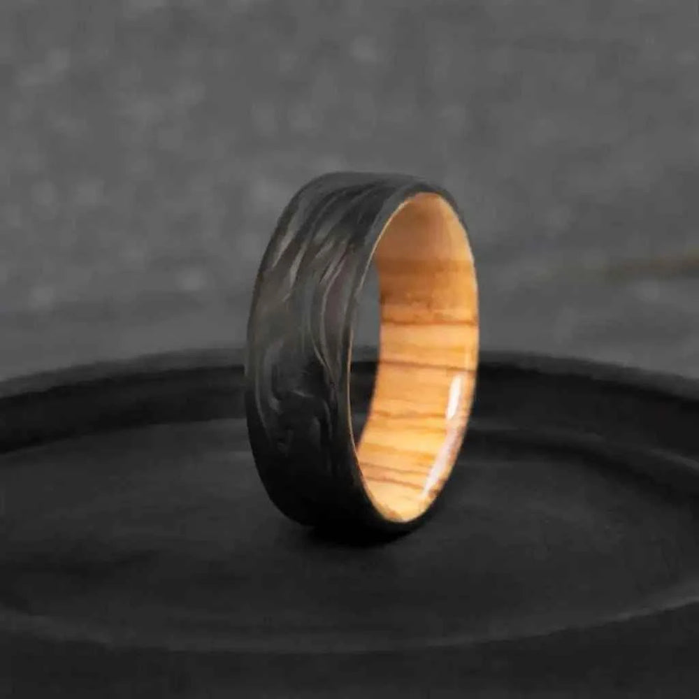 Forged carbon fiber ring with olive wood interior - warm yellow-brown grain - mens handcrafted wedding band